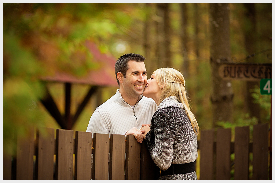 couple by fence in woods